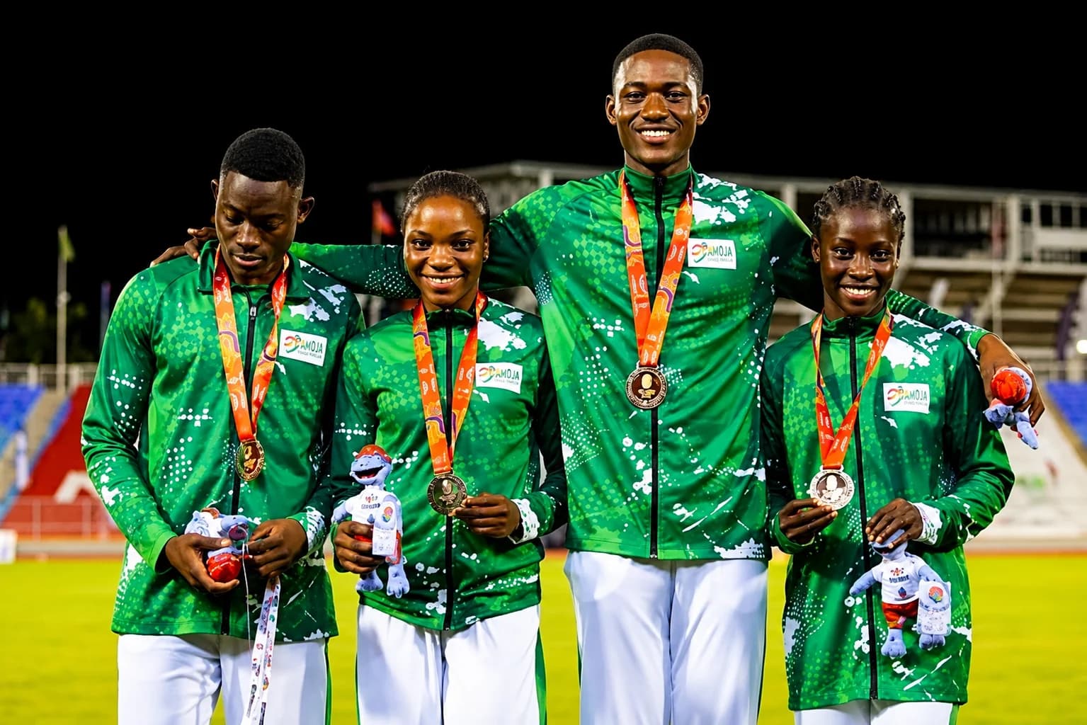 Team Nigeria athletes celebrating with the Nigerian flag after winning medals at the Glasgow 2026 Commonwealth Games.